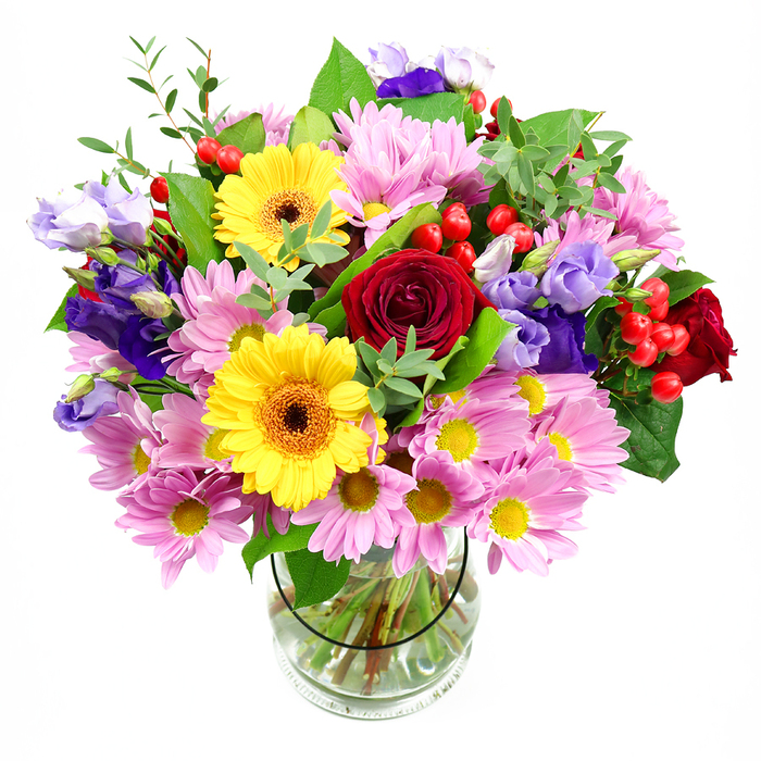 Set against a crisp white background, this generous mixed flower arrangement in a clear glass vase feels like a burst of colour and life ready to brighten any corner of Cranford. At its centre, lush deep red roses unfurl soft, velvety petals, their rich tones giving the bouquet an underlying thread of romance and sincerity. Tucked alongside them, two golden yellow gerbera daisies with distinctive dark brown-orange centres stretch their long petals outward, radiating a cheerful, sunlit energy that immediately catches the eye. Encircling these focal flowers is a gentle halo of pastel pink and lilac daisies or chrysanthemums, each bloom detailed with many slender petals around a small yellow centre, building a sense of soft volume and comfort. Winding through this cushion of flowers are slender stems of lisianthus in shades of purple and cool lavender, their bell-shaped blossoms and elegant buds introducing depth, texture, and a slightly whimsical grace, much like the quiet charm of Cranford's tree-lined avenues. Bright red hypericum berries peek out here and there, smooth and rounded, adding a playful, almost festive layer of detail. Supporting all this colour is a rich collar of green foliage, with broad, glossy leaves at the base and lighter, more delicate sprigs rising among the blooms, giving the design a natural, garden-picked feel. The transparent glass vase reveals orderly stems cut to equal lengths, submerged in clear water that reflects the care of a skilled florist. The arrangement as a whole exudes joy, warmth, and celebration, ideal for birthdays, thank-yous, new home gifts, or any occasion where a flower delivery in Cranford should feel especially thoughtful.